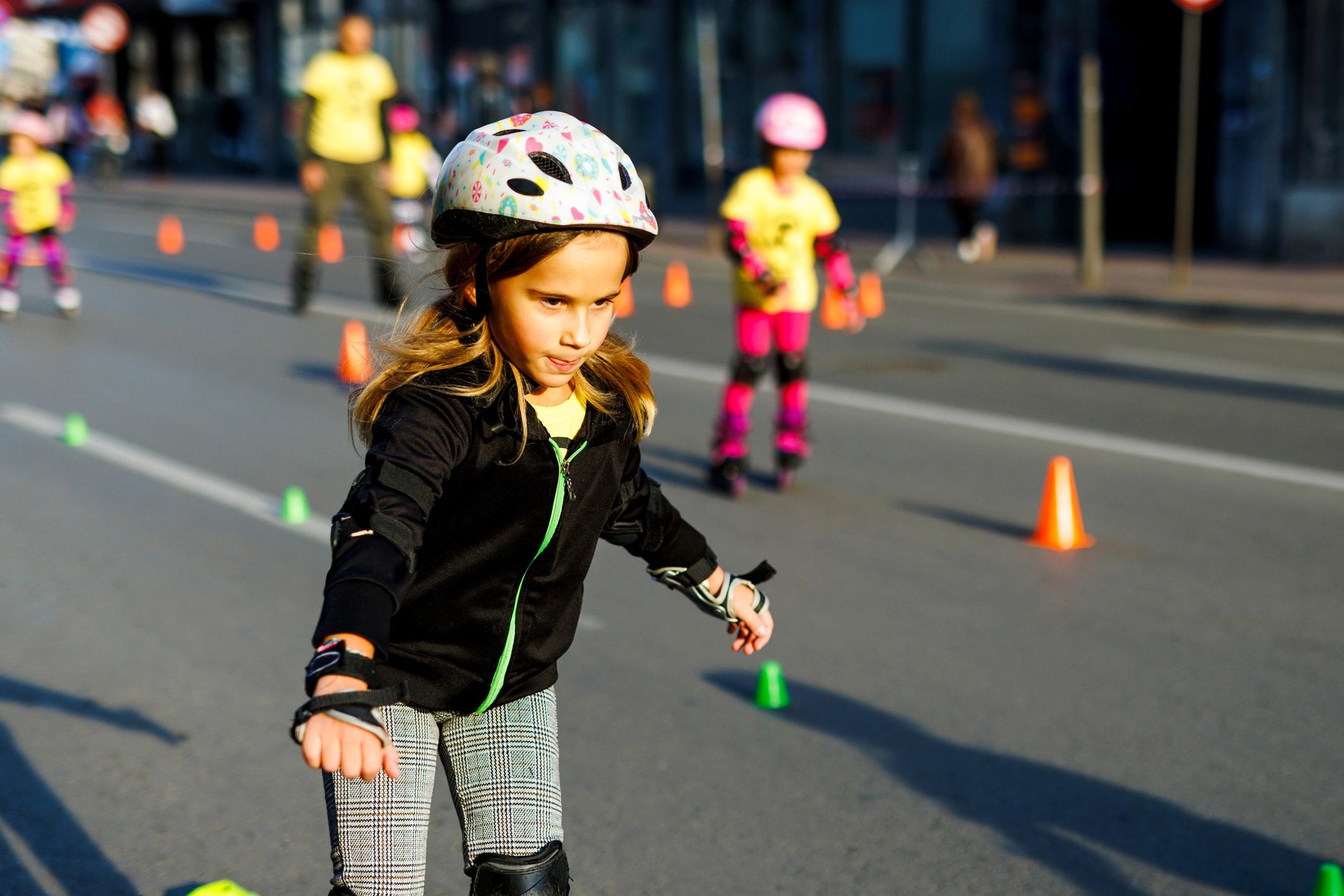 Child practicing inline skating outdoors at sunset